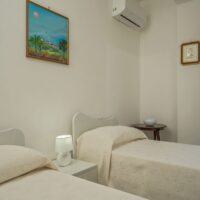 Camera da letto due letti singoli appartamento vacanze Agropoli, comodino, armadio balcone panorama, clima